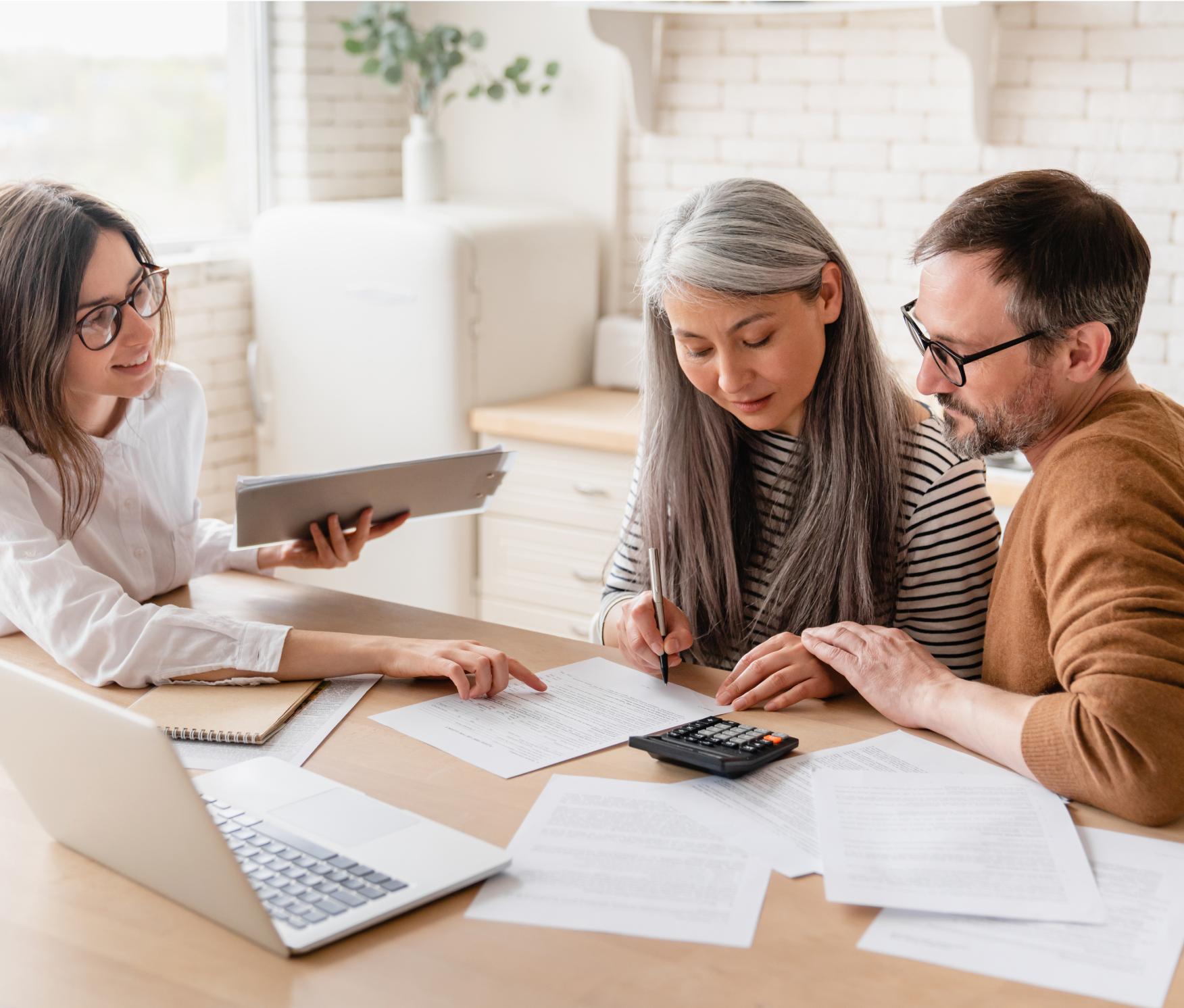 Couple sitting at table with an advisor reviewing documents